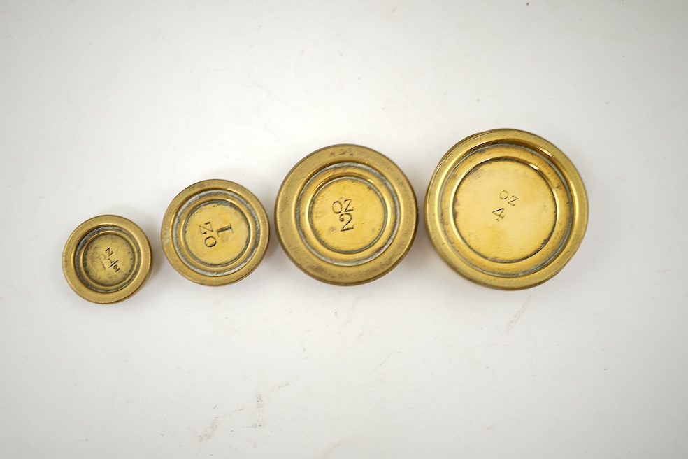 A Sampson Mordan & Co. set of brass postal scales on an oak base with weights, 27cm wide, with engraved prices for Inland Letter Post, etc.